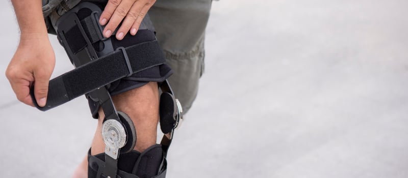 close up of a man tightening his knee brace