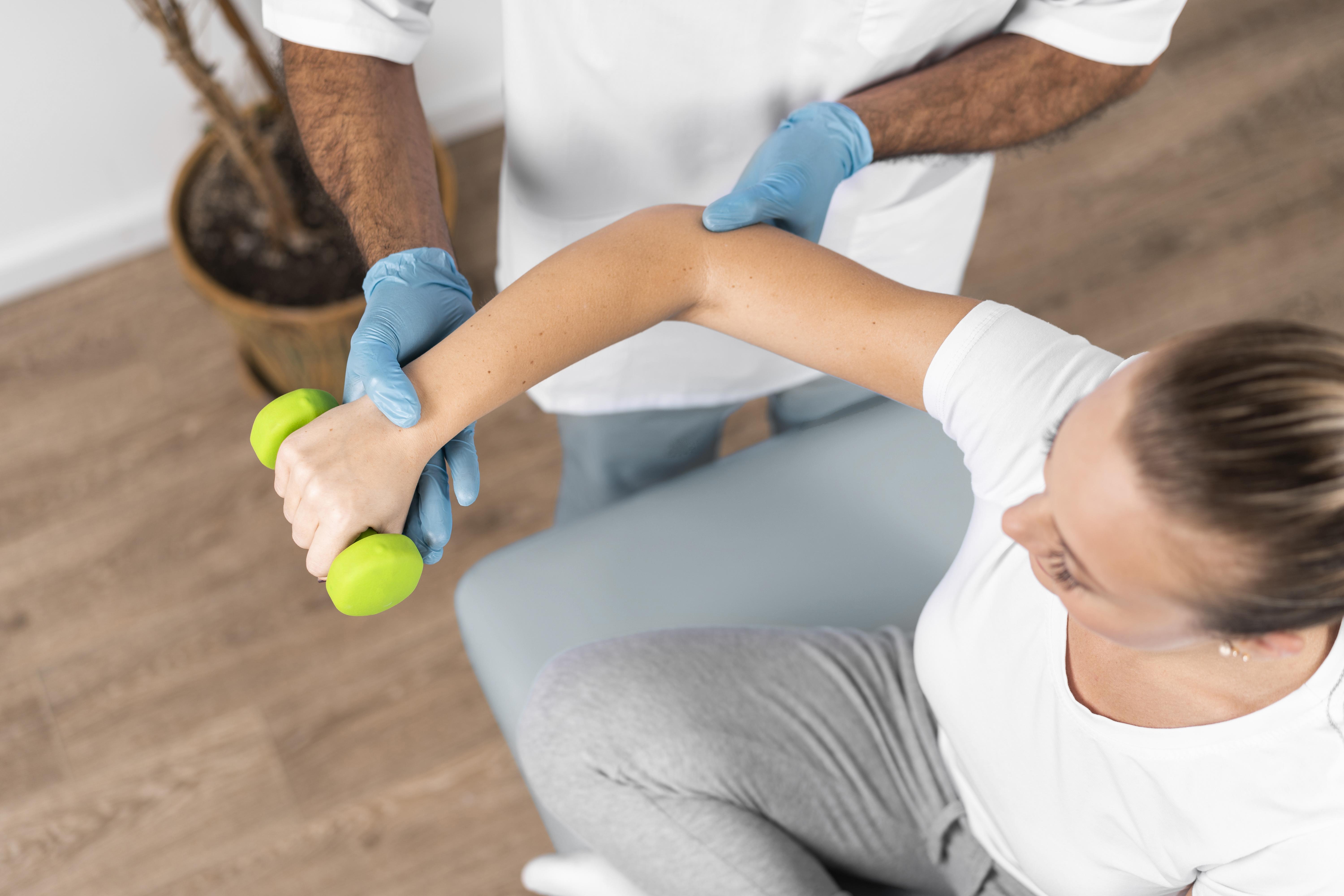 male physical therapist helping woman stretch shoulder